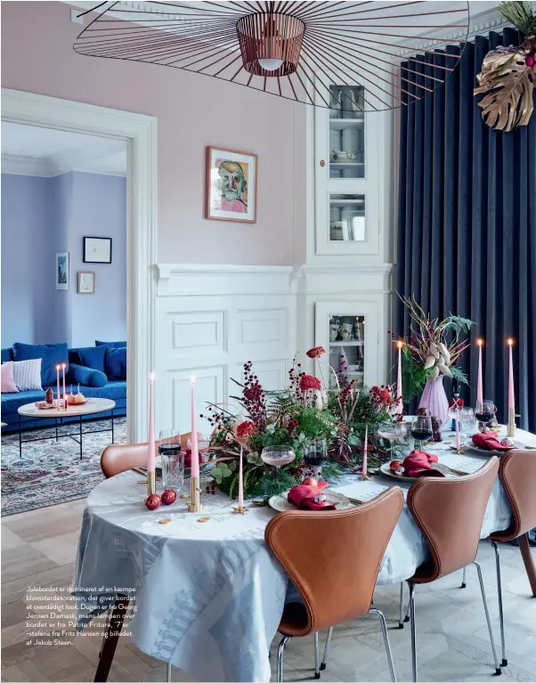  ??  ?? Julebordet er domineret af en kaempe blomsterde­koration, der giver bordet et overdådigt look. Dugen er fra Georg Jensen Damask, mens lampen over bordet er fra Petite Friture, ’7’er’ -stolene fra Fritz Hansen og billedet af Jakob Steen.