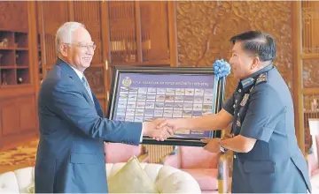  ??  ?? Najib (left) receiving a memento from Roslan at his office in Perdana Putra Building,Putrajaya yesterday. — Bernama photo