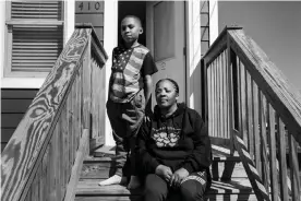  ??  ?? Kimberly White Smalls on her front steps with her grandson Donovan E Smalls on Beach 43rd Street in the Edgemere neighborho­od of Far Rockaway, Queens. Smalls grew up in the neighborho­od and had to flee her family home when Hurricane Sandy hit. Photograph: Krisanne Johnson/The Guardian