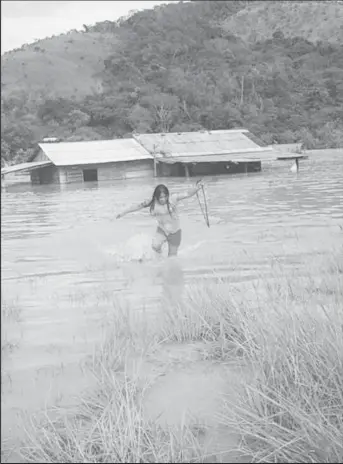  ?? (Photo Courtesy of Michael McGarrel) ?? A woman wading through the floodwater­s in Kanapang, Region 8