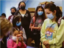  ?? Gabrielle Lurie / The Chronicle ?? Ten-year-old Heidy Martinez (center) waits with other children to get the COVID-19 vaccinatio­n in Richmond.