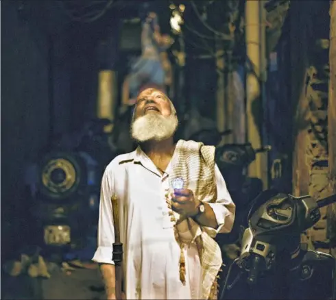  ?? BURHAAN KINU / HT PHOTOS ?? Peer ji walking in the lanes of Old Delhi on a Ramzan night. Below left: Around 3.30 am, when he is done with the rounds, Peer ji returns to his house for sehri.