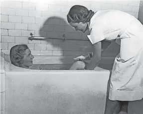  ?? COURTESY THE NATIONAL PARK SERVICE ?? A bath attendant bathes a patron, 1938.