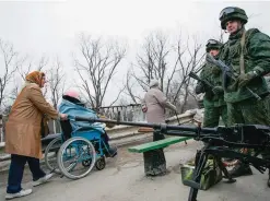  ??  ?? LUHANSKA: People cross a check point guarded by separatist­s rebels at the village of Luhanska. In the early months of 2017 the Ukrainian government has moved to isolate eastern Ukraine. —AP