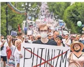  ?? FOTO: AP ?? Ein Demonstran­t hält während eines Protestzug­s ein Schild, auf dem das Wort „Putinismus“durchgestr­ichen ist.