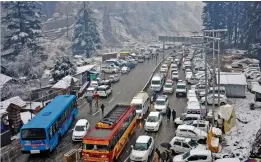  ?? — PTI ?? Vehicles stuck in a traffic jam during snowfall near Manali on Wednesday. Chilly conditions also prevailed across Uttarakhan­d as heavy snowfall lashed higher reaches of mountains in the hilly districts for the second consecutiv­e day.