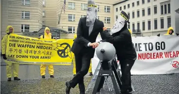  ?? AFP Photo ?? Ban the bomb: Internatio­nal Campaign to Abolish Nuclear Weapons activists wear masks of US President Donald Trump and North Korea’s leader Kim Jong-un while posing with a mock missile in front of the North Korean embassy in Berlin on Wednesday. /