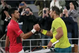  ?? CHRISTOPHE ENA — THE ASSOCIATED PRESS ?? Novak Djokovic, left, congratula­tes Rafael Nadal, who won their quarterfin­al, 6-2, 4-6, 6-2, 7-6 (7-4), at the French Open in Paris on Tuesday.