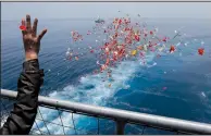  ?? AP/TATAN SYUFLANA ?? A relative on an Indonesia navy ship sprinkles flowers Tuesday during a prayer for the victims of the Lion Air Flight 610 in the waters where the airplane is believed to have crashed in Tanjung Karawang, Indonesia.
