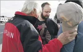  ?? Thomas Peipert Associated Press ?? JACK RASMUSSON, left, of the Billy Graham Rapid Response Team prays with shooting victim James Slaugh this week outside Club Q in Colorado Springs, Colo.