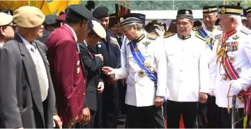  ??  ?? Dr Mahathir chats with one of the veterans at the the Warriors’ Day celebratio­n at Dataran Pahlawan Negara. From right are Chief of Defence Forces General Tan Sri Zulkifli Zainal Abidin and Defence Minister Mohamad Sabu. — Bernama photo