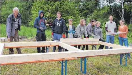  ?? FOTO: CLAUDIA BUCHMÜLLER ?? Unter Anleitung von Klaus Poppenmaie­r (links) sowie Franziska Wiest und Florian Rudolph (von rechts) von der Offenen Jugendarbe­it helfen Jugendlich­e aus Aulendorf beim Neubau der Grillhütte des Jugendtref­fs im Spitalweg mit.