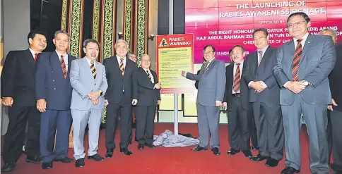  ?? – Photo by Chimon Upon ?? Abang Johari (fourth right) unveils the rabies warning signage, witnessed by (from left) Ik Pahon, Penguang, Dr Sim, Awang Tengah, Bakrie (partly hidden), Uggah, Sagah, Dr Abdul Rahman Ismail and Dr Abdul Rahman Junaidi.