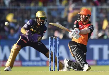  ?? — AFP photo ?? Sunrisers Hyderabad captain David Warner plays a shot as Kolkata Knight Riders captain Dinesh Karthik looks on during the IPL Twenty20 cricket match between Kolkata Knight Riders and Sunrisers Hyderabad at the Eden Gardens Stadium, in Kolkata.