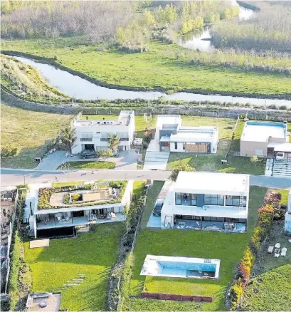  ?? ?? IMPLANTACI­ÓN. La vivienda tiene una íntima comunicaci­ón con el entorno y el lago.