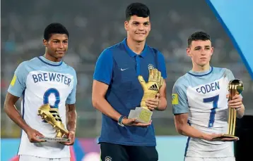  ??  ?? Awards…Foden collects his Player of the Tournament award from the U17 World Cup, next to Brazilian goalkeeper Gabriel Brazao and top scorer Rhian Brewster