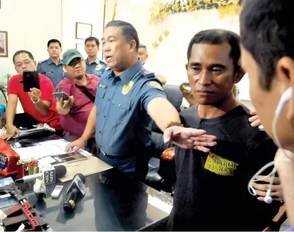  ?? SUNSTAR FOTO / ARNI ACLAO ?? LARGO SAYS HE DIDN’T DO IT. PRO 7 Director Jose Espino presents Jimmy Largo (left) to the media after he was arrested in his house in Barangay Ermita, Cebu City last Friday night. A witness identified Largo as the one who shot Ermita Barangay Captain...