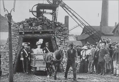  ?? ?? Queen Mary, sitting in a cart being drawn by a pit pony emerges from a mine as miners lift their hats, during a visit to the Lewis Merthyr Colliery in Trehafod, Wales in the 1920s