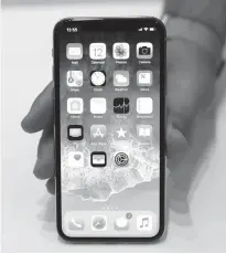  ??  ?? BELOW: The new iPhone X is displayed Sept. 12 in Cupertino, Calif. Apple is offering a nifty way to unlock its new iPhone X ... just stare at it. Face ID, Apple’s name for its facial-recognitio­n technology, replaces the fingerprin­t sensor found on...