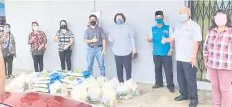  ??  ?? Liew (fourth right) handing over food baskets to Pastor Jery Mengala Martin (on her right) and others at The Christian Revival Church Takada.