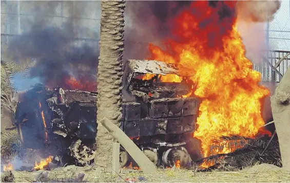  ?? AP FILE PHOTO ?? DANGEROUS DEVICES: A U.S. Army Bradley armored vehicle burns next to a junction on the airport highway in Baghdad in 2004. IEDs have rocked many vehicles in Afghanista­n and Iraq — including the one driven by Brian Callahan in 2006 in Ramadi, Iraq.