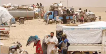  ?? — Reuters ?? Internally displaced people who fled Raqqa city gather near vehicles carrying their belongings in a camp near Ain Issa, Raqqa Governorat­e, Syria.