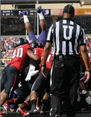  ?? AP PHOTOS ?? TCU running back Aaron Green has his legs up as he goes over the line scoring a touchdown.