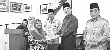  ??  ?? Wan Junaidi (second right) presenting the grant to a recipient.