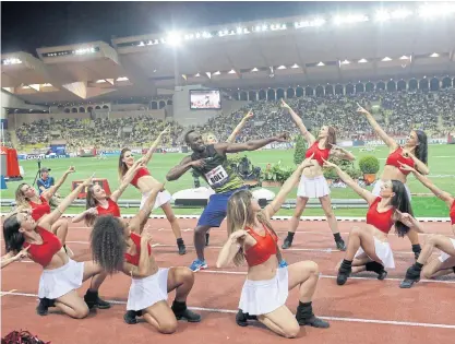  ??  ?? Jamaica’s Usain Bolt, surrounded by cheerleade­rs, gestures after the podium ceremony at the Louis II Stadium in Monaco.