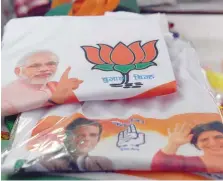  ?? — AFP ?? T-shirts bearing pictures of Prime Minister Narendra Modi, Congress President Rahul Gandhi and his sister Priyanka Gandhi are displayed at a shop in New Delhi.