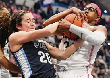  ?? Jessica Hill / Associated Press ?? Villanova’s Maddy Siegrist, left, and UConn’s Ayanna Patterson, right, fight for the ball in the first half on Sunday in Hartford.