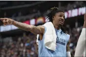  ?? DAVID ZALUBOWSKI — THE ASSOCIATED PRESS ?? Memphis Grizzlies guard Ja Morant talks with teammates on the bench in the first half of a game against the Denver Nuggets on Friday in Denver.