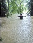  ??  ?? A man seen wading in a flooded area at one of the affected villages. - photo courtesy of Mastupang Somoi