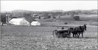  ?? SUBMITTED PHOTO ?? An Amishman tends to his fields in Lancaster County. Note the common Schweitzer (Swiss) bank barn in the background, but painted traditiona­lly white by Plain People.