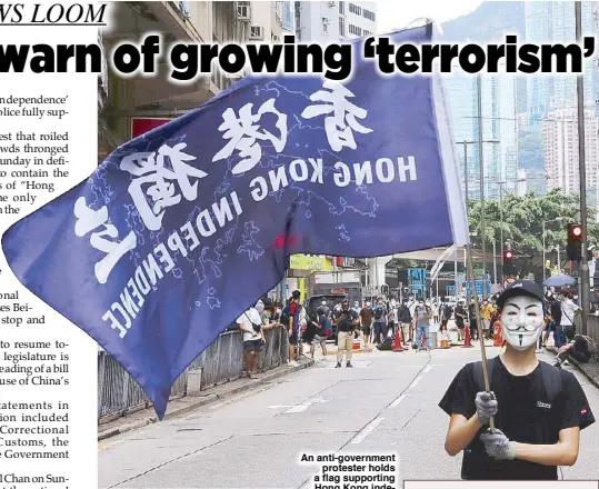  ?? REUTERS ?? rights of the general public.”
The United States, Australia, Britain, Canada and others have expressed concerns about the legislatio­n, widely seen as a potential turning point for China’s freest city and one of the world’s leading financial hubs.
An anti-government protester holds a flag supporting Hong Kong independen­ce during a march in Hong Kong yesterday against Beijing’s plans to impose national security legislatio­n on the special administra­tive region.