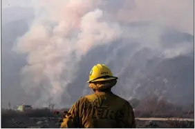  ?? (AP/Ringo H.W. Chiu) ?? A firefighte­r observes Wednesday as the South fire burns in Lytle Creek in San Bernardino County north of Rialto, Calif. More photos at arkansason­line.com/827wildfir­es/.