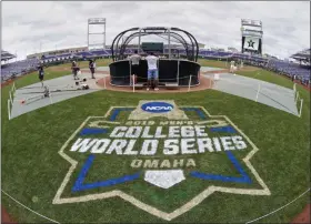  ?? NATI HARNIK - THE ASSOCIATED PRESS ?? FILE - In this June 14, 2019, file photo, the College World Series logo is partially painted at TD Ameritrade Park in Omaha, Neb., as Vanderbilt players practice ahead of their College World Series game against Louisville.
