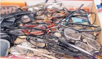  ??  ?? A box full of lost eyeglasses from this year’s Balloon Fiesta wait to be claimed at the event’s headquarte­rs.