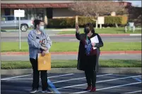  ??  ?? Greengate Principal Jonelle Castiglia (right) speaks with a parent as students arrive on campus for in-person instructio­n.