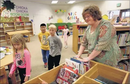  ?? STAN CARROLL/THE COMMERCIAL APPEAL ?? DeSoto County School District’s Parent of the Year, Kelly Phillips — helping out in the library at Lewisburg Primary School — is always looking for ways to assist. She said, “Helping to ease the workload on faculty and staff makes more time available...