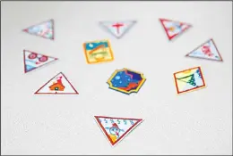  ??  ?? In this July 21, 2017 photo, a Girl Scout badge for learning how to program a robot is seen beneath a sample of new badges focused on science, technology, enginnerin­g, and math
in Owings Mills, Md. (AP)