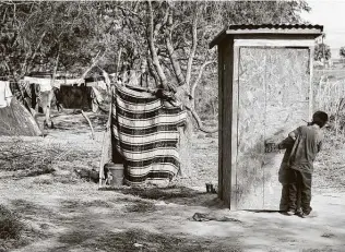  ?? Bob Owen / Staff photograph­er ?? A young boy waits to use an outhouse next to the Rio Grande in the refugee camp in Matamoros, Mexico. Thousands of immigrants are awaiting a chance for asylum in the United States.