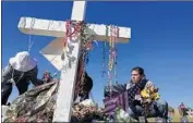  ?? Joe Cavaretta Florida Sun Sentinel ?? VOLUNTEERS tidy up a memorial in Parkland. Fla., for the 17 students killed in a shooting last month.