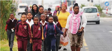  ?? PICTURE: CINDY WAXA ?? BE VIGILANT: Concerned about the safety of their children, these parents walk their children to school.