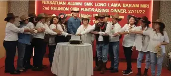  ?? ?? Dennis (eighth left) joins the organising committee members and other guests cutting the cake to mark the fifth anniversar­y of Persatuan Alumni SMK Long Lama Baram.