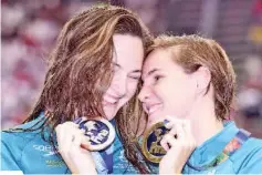  ?? — AFP photo ?? Gold medallist Australia’s Bronte Campbell (R) celebartes with her sister, bronze medallist, Australia’s Cate Campbell, during the podium ceremony of the women’s 100m freestyle swimming event at the 2015 FINA World Championsh­ips in Kazan on August 7,...