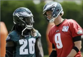  ?? MATT SLOCUM — THE ASSOCIATED PRESS ?? Philadelph­ia Eagles running back Jay Ajayi (26) and Nick Foles (9) talk during an organized team activity at the team’s practice facility last week in Philadelph­ia.