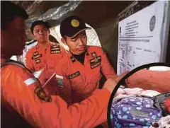  ??  ?? PASUKAN penyelamat Indonesia mengemas kini rekod penemuan cebisan mayat mangsa.