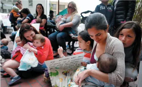  ?? AP FILE PHOTO ?? Mildred Musni, right, breast feeds her son Eliseo and is joined by other mothers in protest at the main entrance of the city Human Services Agency in San Francisco in March 2016. Months before the protest, Musni was forced to cover up by a security guard when she attempted to feed Eliseo inside the facility. Nursing moms face additional challenges when they return to the workplace.