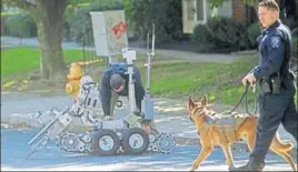  ?? REUTERS ?? A dog and a bomb disposal robot outside a post office which had been evacuated in Delaware.